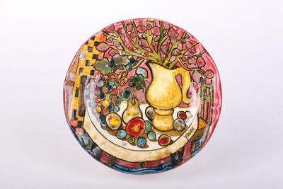 a plate with a painting of a vase and fruit on it
