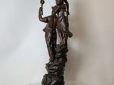 statue of a woman and child on a rock with a bird in her hand