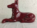 a red dog statue sitting on a white surface