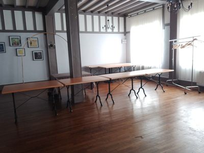 une pièce avec des tables et des chaises, ainsi qu'un lustre