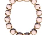 un gros plan d'un bracelet orné de perles de verre roses sur fond blanc