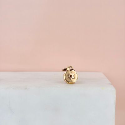 une bague plaquée or posée sur un bloc de marbre blanc