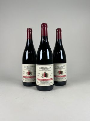 trois bouteilles de vin rouge posées côte à côte sur une table