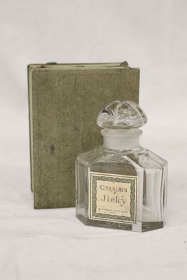 un petit flacon de parfum à côté d'une petite boîte