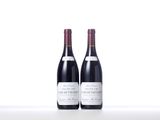 two bottles of red wine sitting on top of a white table