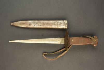 an old knife is laying on a table next to a leather sheath
