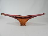 an orange glass bowl sitting on top of a white table