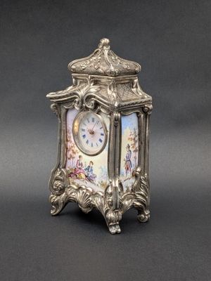 une horloge en argent posée sur une table