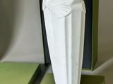 a white vase sitting on top of a green box