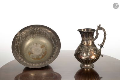 un pichet en argent et une assiette en argent posés sur une table