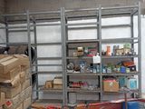 un garage où s'entassent de nombreux cartons et outils sur les étagères