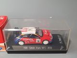 a small red car in a clear box on a table
