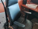 une chaise de bureau noire placée devant un bureau sur lequel se trouve un ordinateur