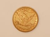 a close up of a gold coin on a white surface