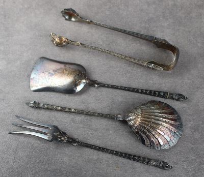 trois cuillères en argent et une fourchette sont posées sur une table