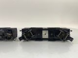 two black train cars sitting next to each other on a white surface