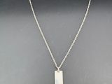 un collier en argent avec un pendentif rectangulaire monté sur une chaîne