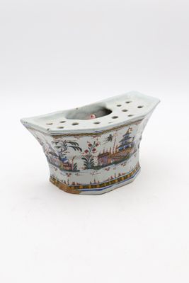 un petit vase blanc orné d'un bateau