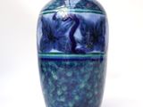 a blue vase that is sitting on a white surface