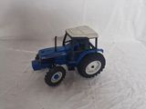 a toy tractor that is sitting on a white surface