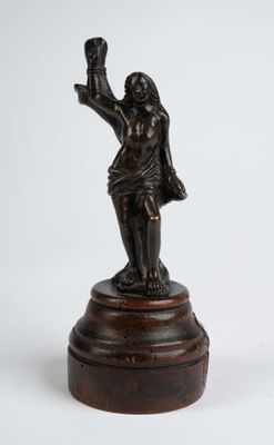 une vieille statue en bronze représentant une femme tenant une bouteille