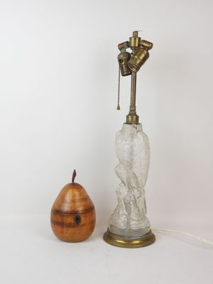 a lamp that is next to a pear on a table