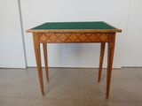 une petite table en bois recouverte d'un plateau vert