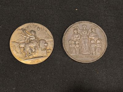 deux pièces d'argent représentant un homme à cheval et une femme à cheval