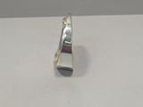silver plated ring on a white surface with a small metal object