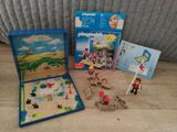 une boîte de Playmobil posée par terre à côté d'autres jouets