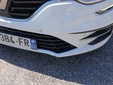 a close up of a white car parked in a parking lot