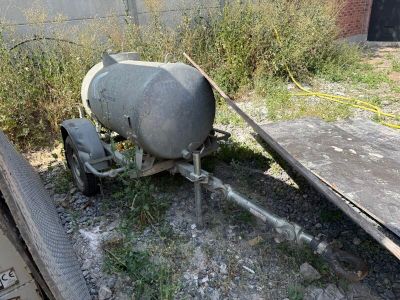 a cement mixer sitting on the ground next to a trailer
