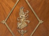 a wooden cabinet with a metal decoration on it