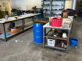 a large room with a lot of work tables and blue barrels