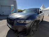 La BMW X4 est garée devant une tente