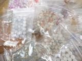 several bags of beads are sitting on a table next to a pair of scissors