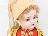 an image of a doll of a woman wearing a red dress and a yellow hat