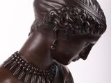 bronze statue of a woman with a necklace on her neck