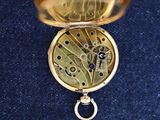 a close up of a pocket watch on a blue cloth