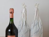 two bottles of wine sitting next to each other on a table