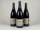 trois bouteilles de vin posées l'une à côté de l'autre sur une table