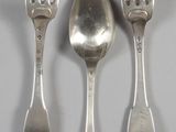 three spoons and two forks on a table