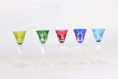 four different colored wine glasses are lined up in a row