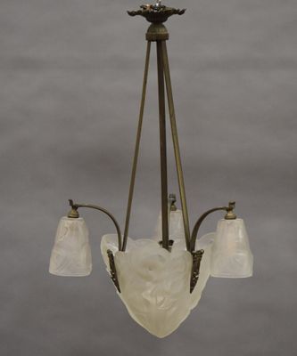 un lustre ancien muni de trois abat-jours en verre suspendu au plafond