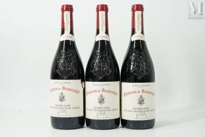 three bottles of red wine are lined up on a white surface