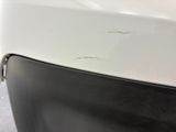 a close up of a white car with a hole in the door