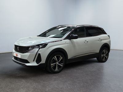 un SUV blanc garé dans une pièce au sol noir