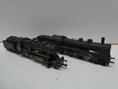 un train noir sur un fond blanc, à côté d'un train rouge et noir