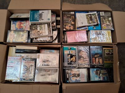un grand nombre de dvd dans une boîte posée sur le sol
