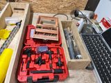 a red tool box with tools in it next to a laptop